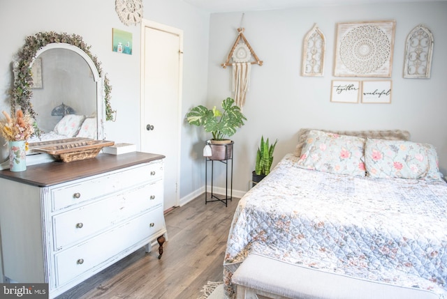 bedroom featuring baseboards and wood finished floors