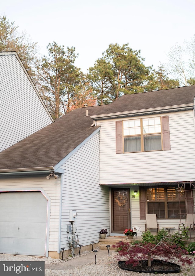 view of front of home with a shingled roof and an attached garage