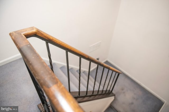 stairway featuring baseboards and carpet