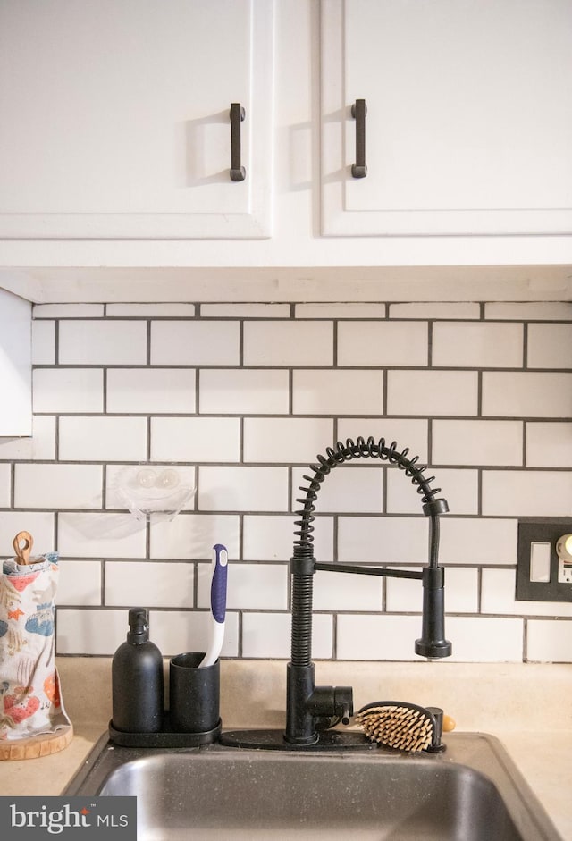 interior details with a sink and decorative backsplash