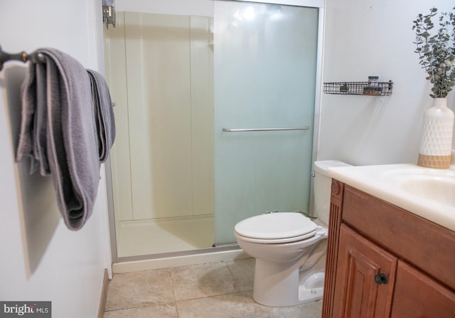 bathroom with toilet, tile patterned floors, a shower stall, and vanity