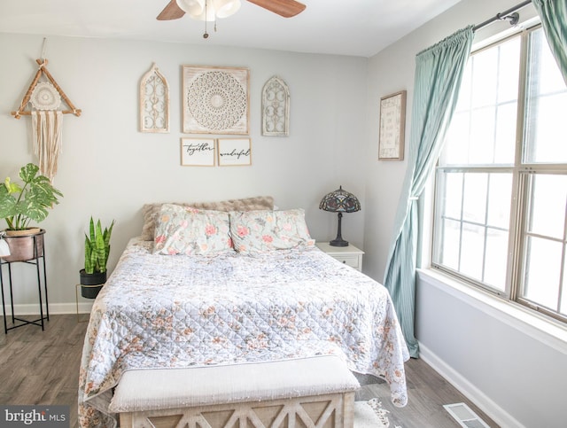 bedroom featuring ceiling fan, baseboards, visible vents, and wood finished floors