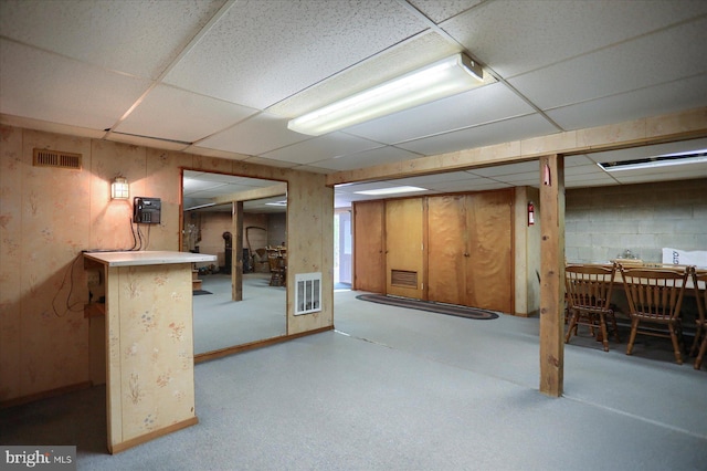 finished below grade area with visible vents and a drop ceiling