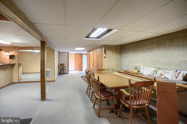 dining space featuring concrete flooring, a paneled ceiling, and visible vents
