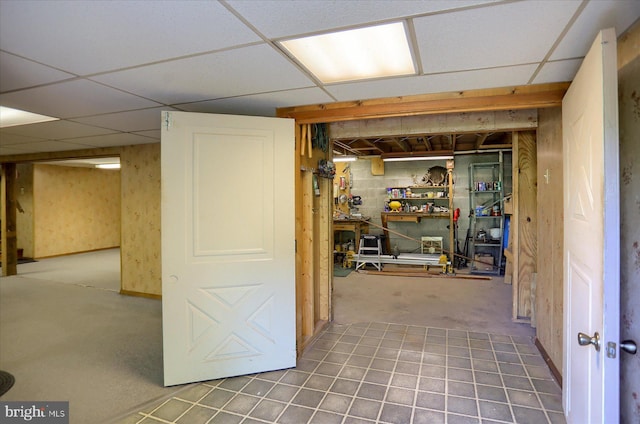 finished below grade area featuring a drop ceiling and carpet