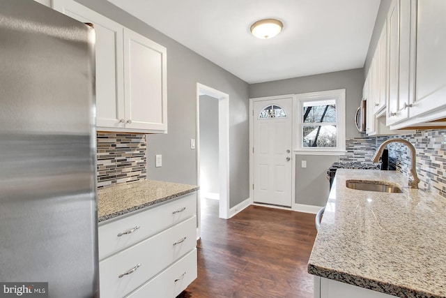 324 Woodbourne Ave, Baltimore, MD 21212 - kitchen with stainless steel appliances, light stone counters, decorative backsplash, white cabinets, and dark wood-style floors
