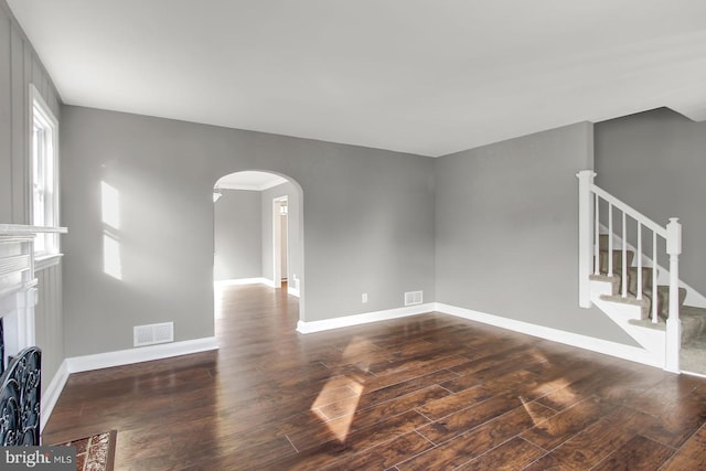 324 Woodbourne Ave, Baltimore, MD 21212 - unfurnished living room featuring arched walkways, dark wood-style flooring, and stairway