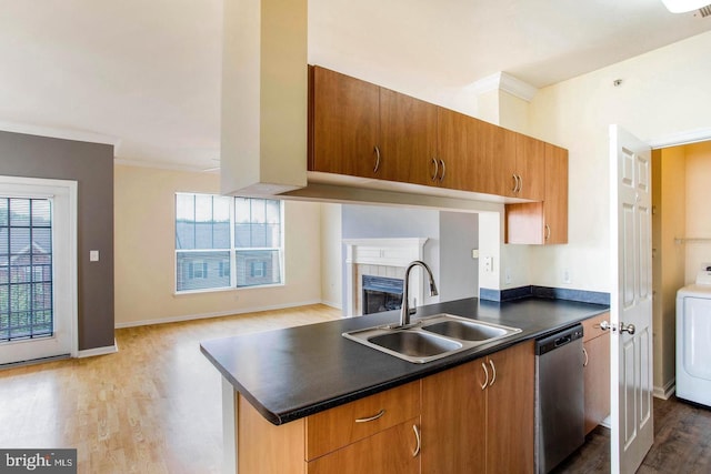 kitchen with stainless steel dishwasher, crown molding, wood finished floors, dark countertops, and a sink