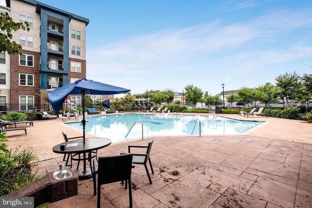 pool with a patio and fence