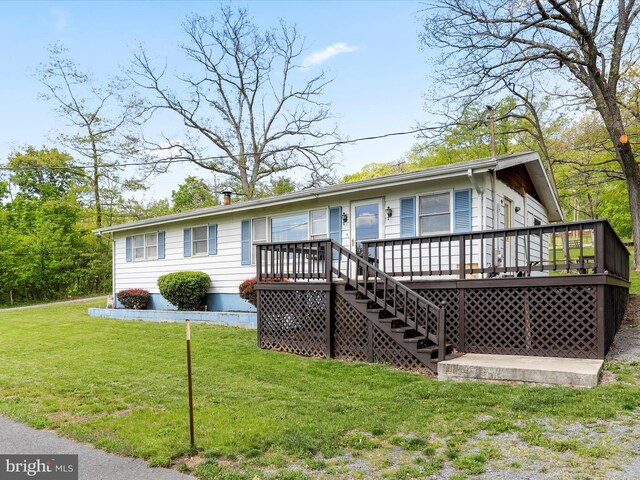 view of front of home featuring stairs, a front lawn, and a wooden deck