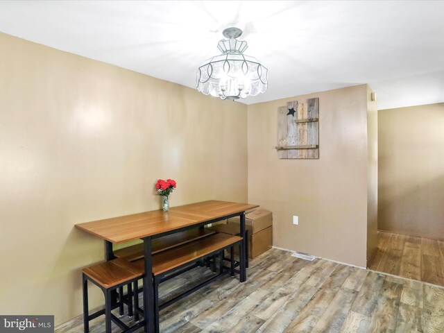 dining space with an inviting chandelier and wood finished floors