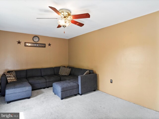 living room with ceiling fan and carpet