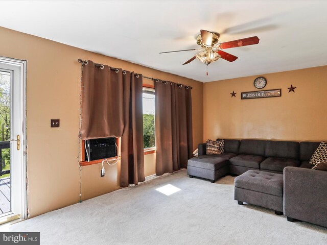 carpeted living area with a healthy amount of sunlight, ceiling fan, and cooling unit