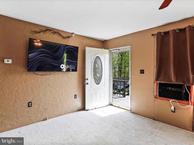 entryway featuring carpet floors, a textured wall, ceiling fan, and cooling unit