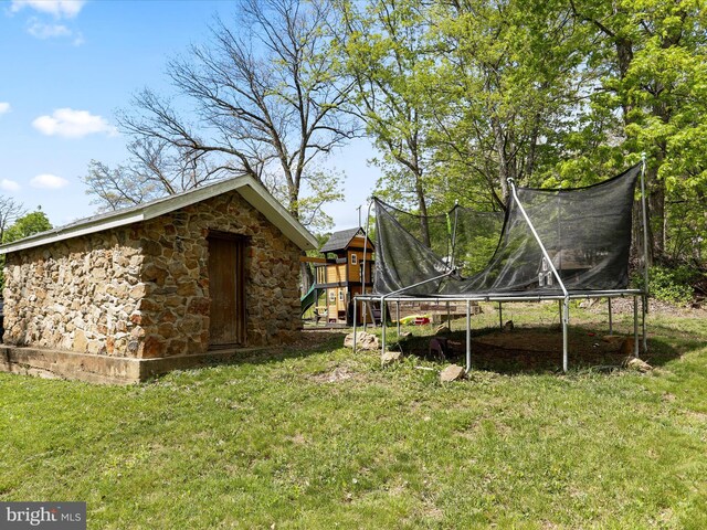 view of yard featuring a playground and a trampoline