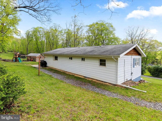 view of side of property with a playground and a yard