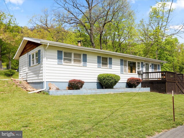 ranch-style house featuring a wooden deck and a front yard