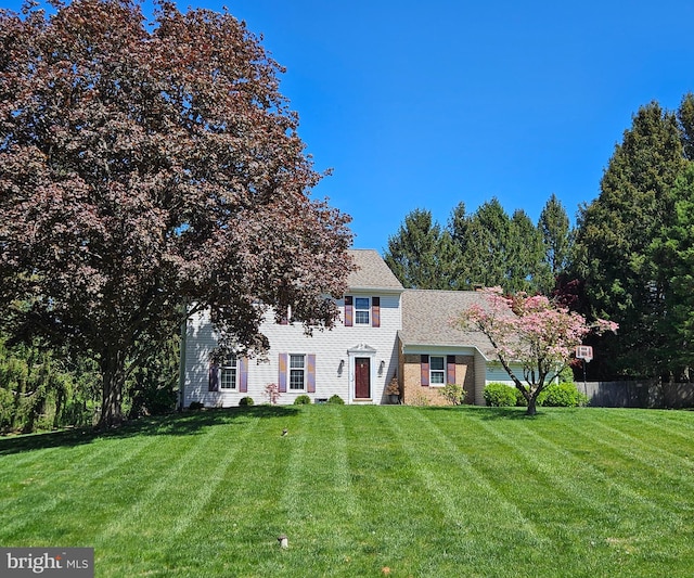 colonial home with fence and a front yard