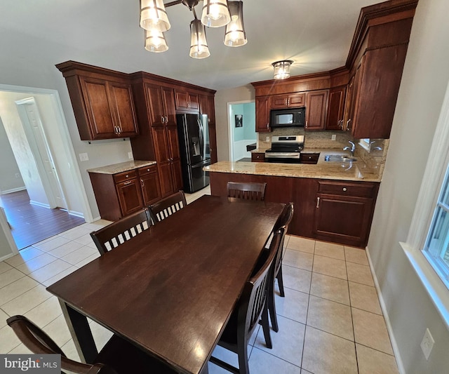 kitchen featuring backsplash, a sink, black appliances, a chandelier, and light tile patterned flooring