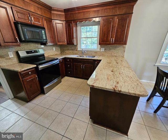 kitchen featuring black microwave, decorative backsplash, a sink, and electric stove