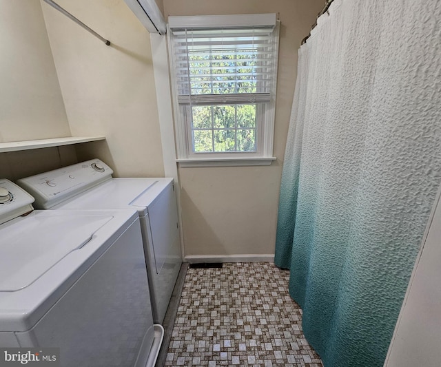 clothes washing area with laundry area, baseboards, and washer and dryer