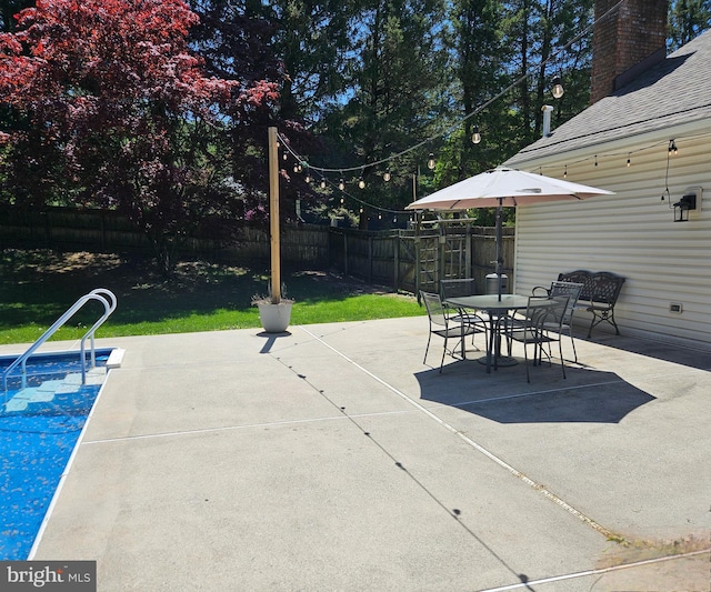 view of patio / terrace with a fenced in pool, a fenced backyard, and outdoor dining space