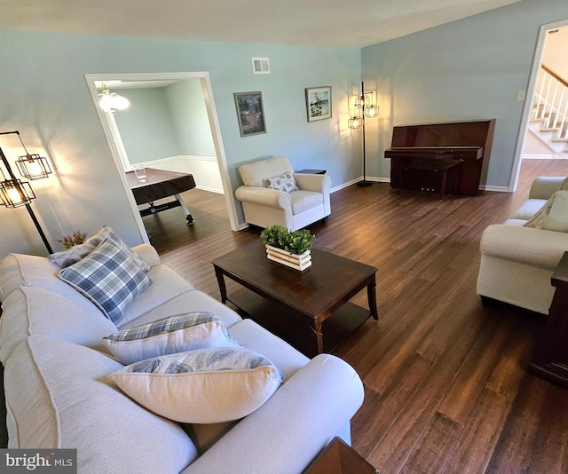 living area featuring stairway, baseboards, wood finished floors, and visible vents