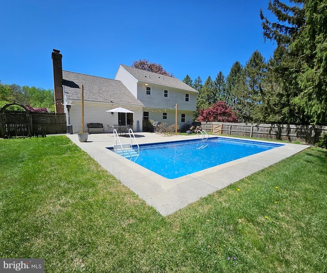 view of swimming pool featuring a yard, a fenced in pool, a fenced backyard, and a patio area