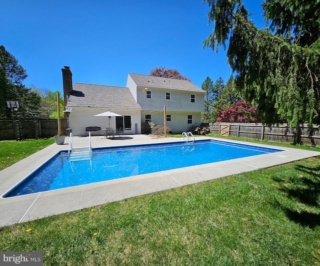 view of swimming pool featuring a lawn, a fenced in pool, and a fenced backyard