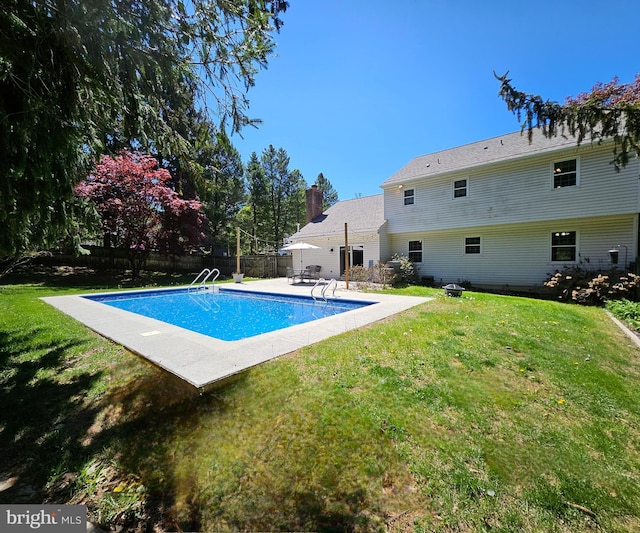 view of swimming pool with a lawn, fence, a fenced in pool, and a patio