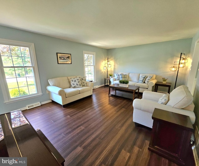living area featuring baseboards, dark wood-style floors, and visible vents