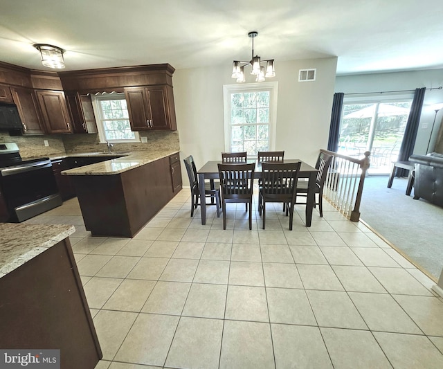 kitchen with an inviting chandelier, dark brown cabinetry, visible vents, tasteful backsplash, and stainless steel electric stove