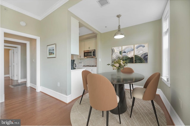 2600 Pennsylvania Ave NW Unit 601/6D, Washington, DC 20037 - dining area with light wood-style floors, baseboards, and ornamental molding