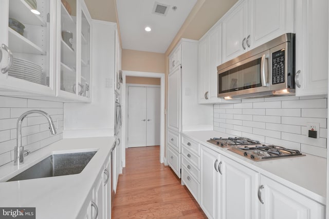 2600 Pennsylvania Ave NW Unit 601/6D, Washington, DC 20037 - kitchen with stainless steel appliances, a sink, white cabinets, and recessed lighting