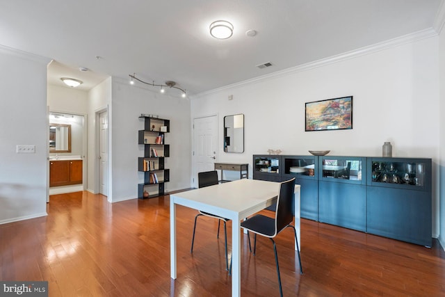 dining area with crown molding, wood finished floors, and visible vents