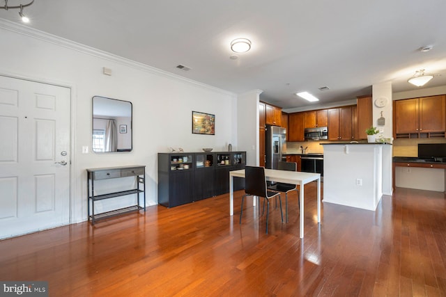 dining space with visible vents, ornamental molding, and dark wood finished floors