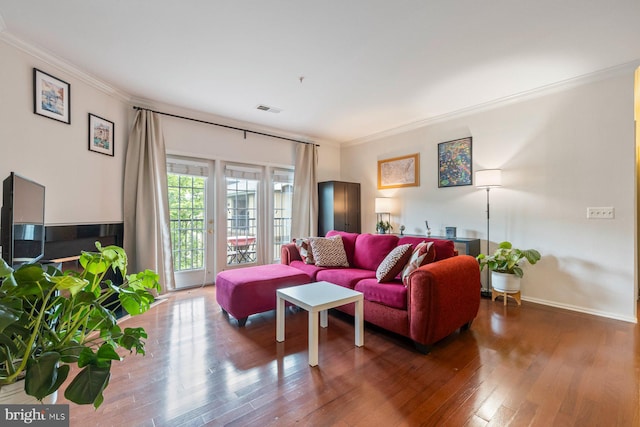 living area featuring crown molding, baseboards, wood finished floors, and visible vents