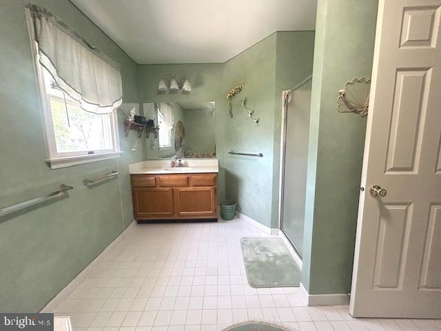 full bath with vanity, tile patterned flooring, baseboards, and a stall shower