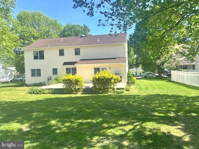 back of house featuring fence and a yard
