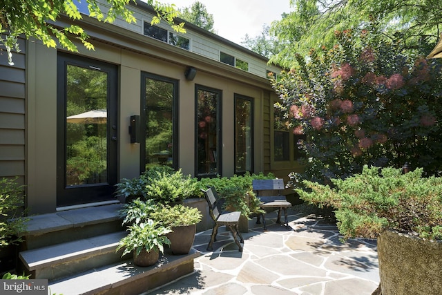 view of exterior entry featuring a patio area
