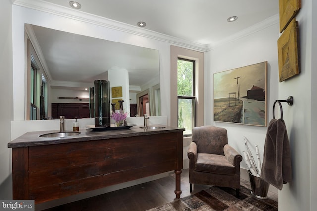 bathroom with crown molding, wood finished floors, double vanity, and recessed lighting