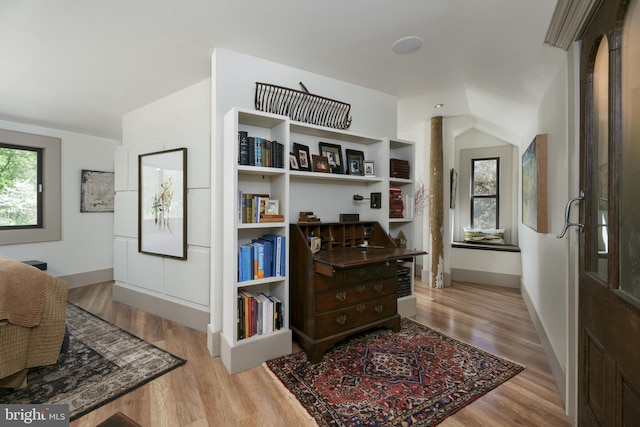 hallway featuring wood finished floors and baseboards