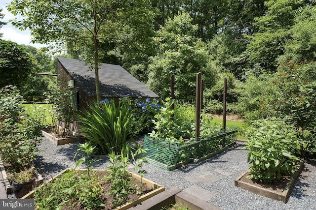 view of yard with a vegetable garden, a storage shed, and an outdoor structure
