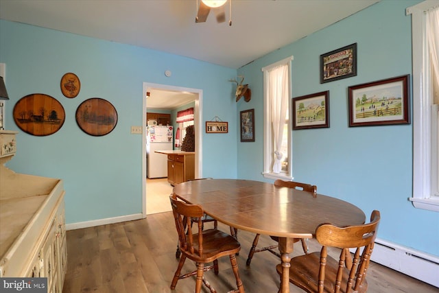 dining space with ceiling fan, wood finished floors, and a baseboard radiator