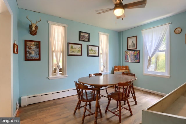 dining space with baseboards, ceiling fan, wood finished floors, and a baseboard radiator