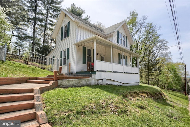 country-style home with a porch and a front yard