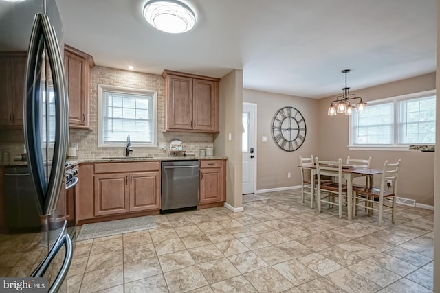 20 Aspen Dr, Pennsville, NJ 08070 - kitchen featuring a sink, decorative backsplash, a wealth of natural light, and stainless steel appliances