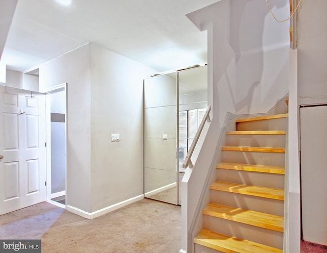 staircase with carpet floors and baseboards