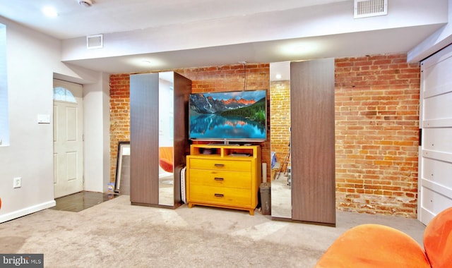 living room featuring visible vents, carpet flooring, and brick wall