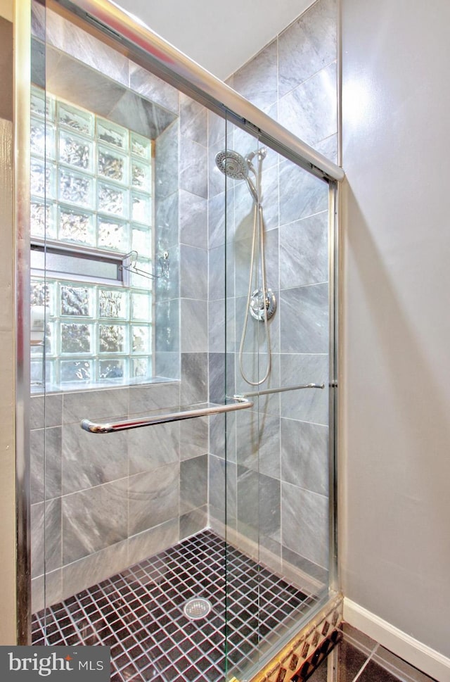 bathroom with baseboards and a shower stall